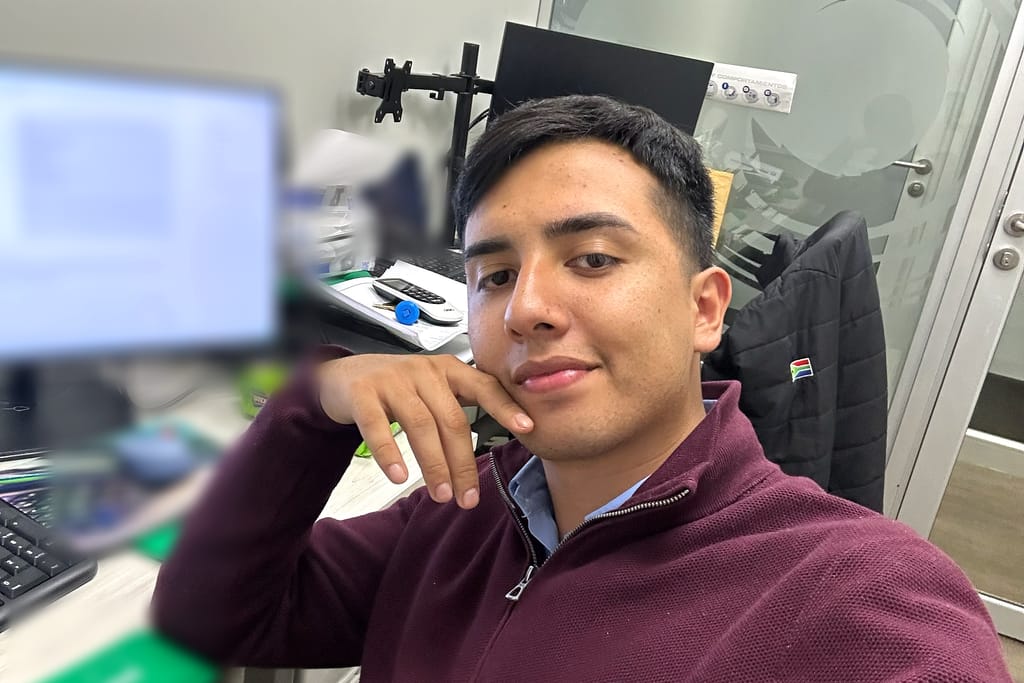 Dylan Alexander Oyarzún en su puesto de trabajo, frente al monitor y el teclado